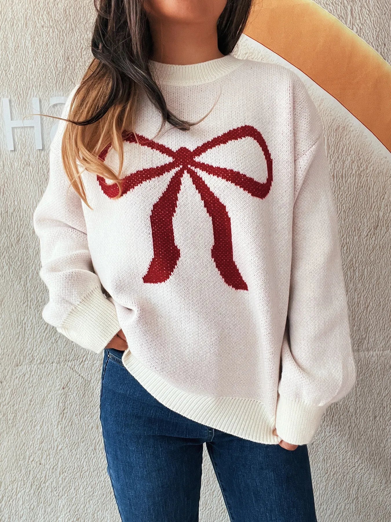 Stylish Bow Pattern Casual Long Sleeve Sweater for Effortless Everyday Wear, displaying a large red bow graphic, ideal for a chic and comfortable outfit with jeans.