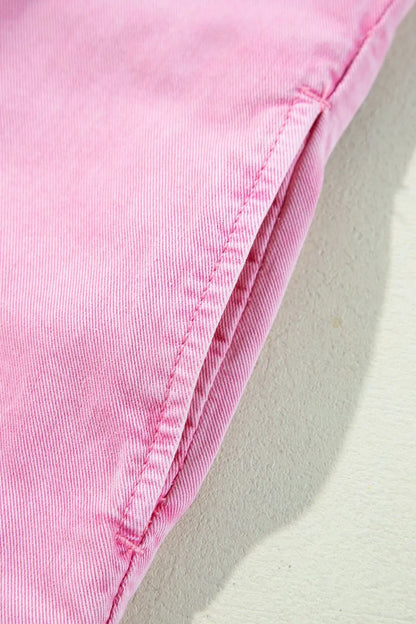 Close-up detail of the button down short sleeve denim dress with pockets, highlighting the garment's pink stitching. Perfect for casual wear and made from 100% cotton.