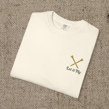 Tee It High Let It Fly Graphic Tee in soft US cotton, showcasing a minimalistic design with crossed golf clubs on a beige background, perfect for a stylish casual look.