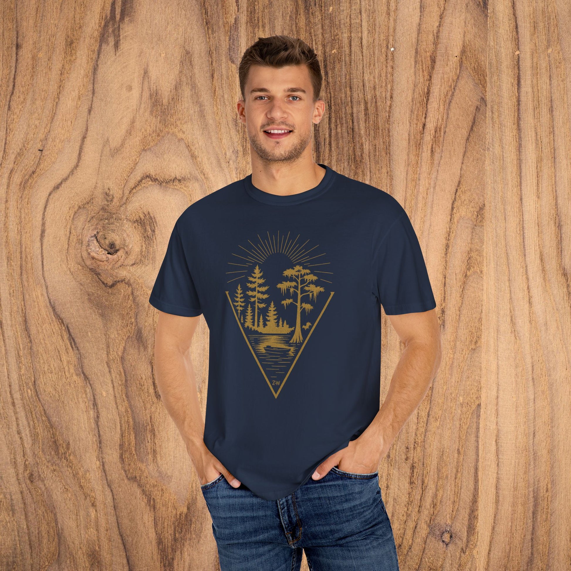 Nature Outdoor Vibes Tee worn by a model in a navy t-shirt with a distinctive forest graphic, highlighting the soft 100% US cotton fabric, ideal for outdoor activities.