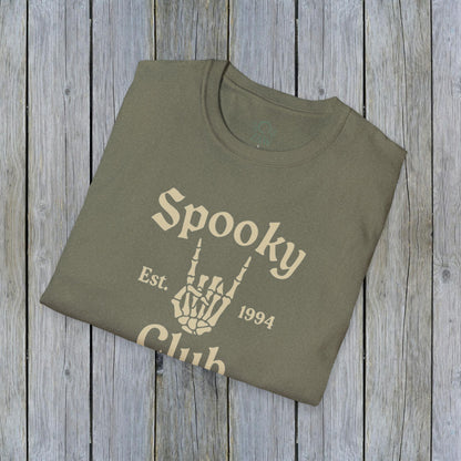Folded Unisex Spooky Club Tee in olive green, set against a wooden background, highlighting the unique skeleton hand graphic and 'Spooky Club Est. 1994' print. Crafted from soft, durable 100% cotton, great for Halloween outings.