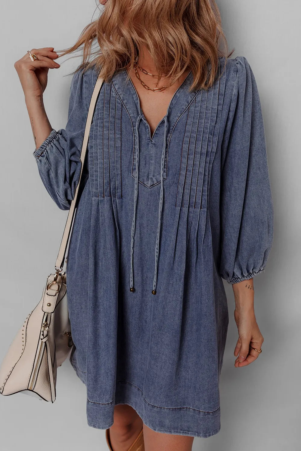 Front view of a model in the Tie Neck Long Sleeve Mini Denim Dress, emphasizing the stylish neckline and comfortable silhouette.