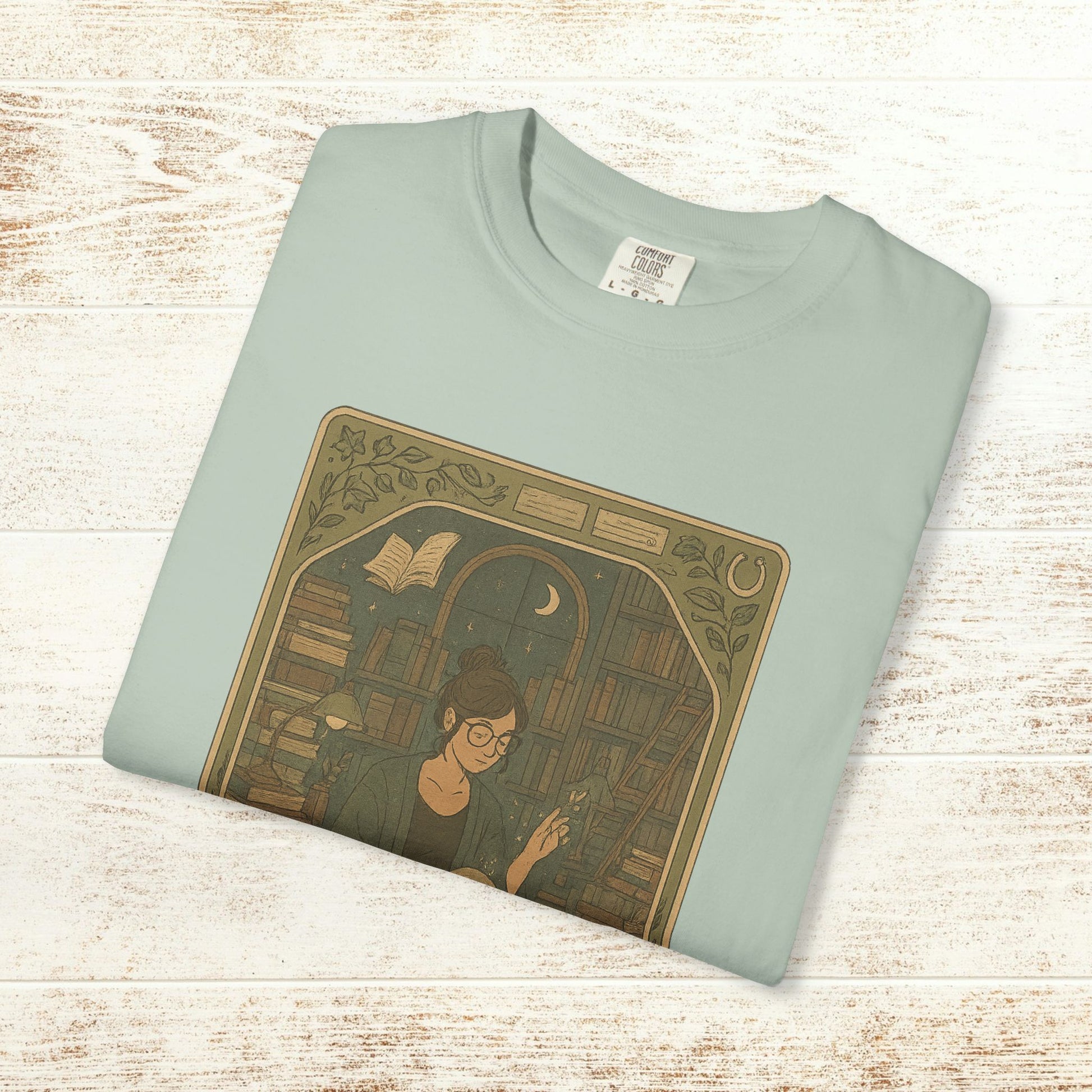Page Turner Tarot Tee in light mint, soft cotton t-shirt featuring an artistic print of a woman in a library, available in sizes S to 4XL, eco-friendly and comfortable.