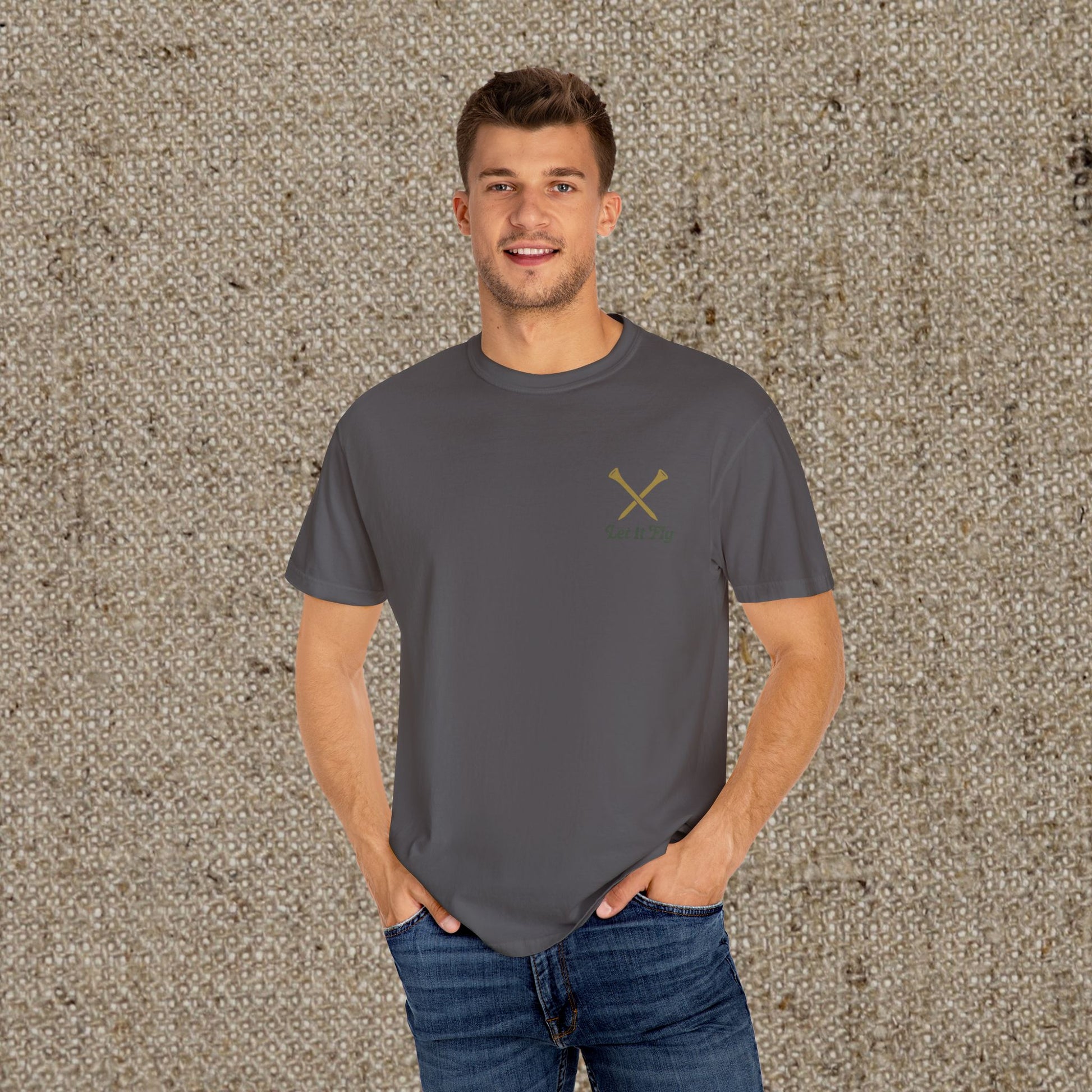 Model wearing Tee It High Let It Fly Graphic Tee in charcoal with a subtle crossed golf clubs logo; a trendy choice for golf fans.