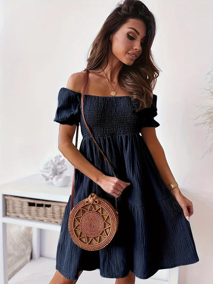 Full Size Ruffled Off-Shoulder Dress with Short Sleeves - Stretchy, Chic & Ruched Design in navy blue, featuring a model standing gracefully with a stylish bag.