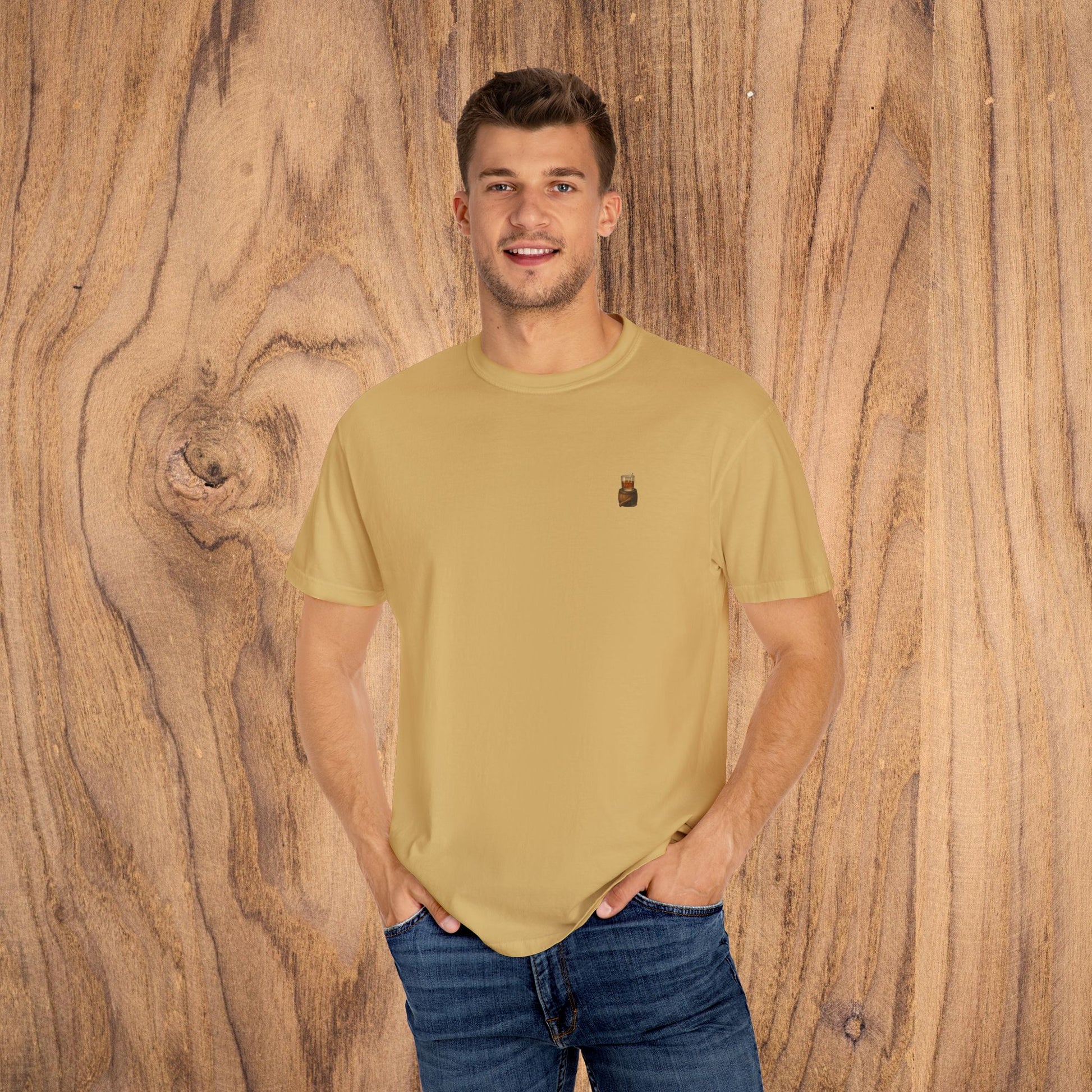 Model wearing a Premium Southern Made T-Shirt in mustard yellow, displaying a casual and fashionable look against a wooden background.
