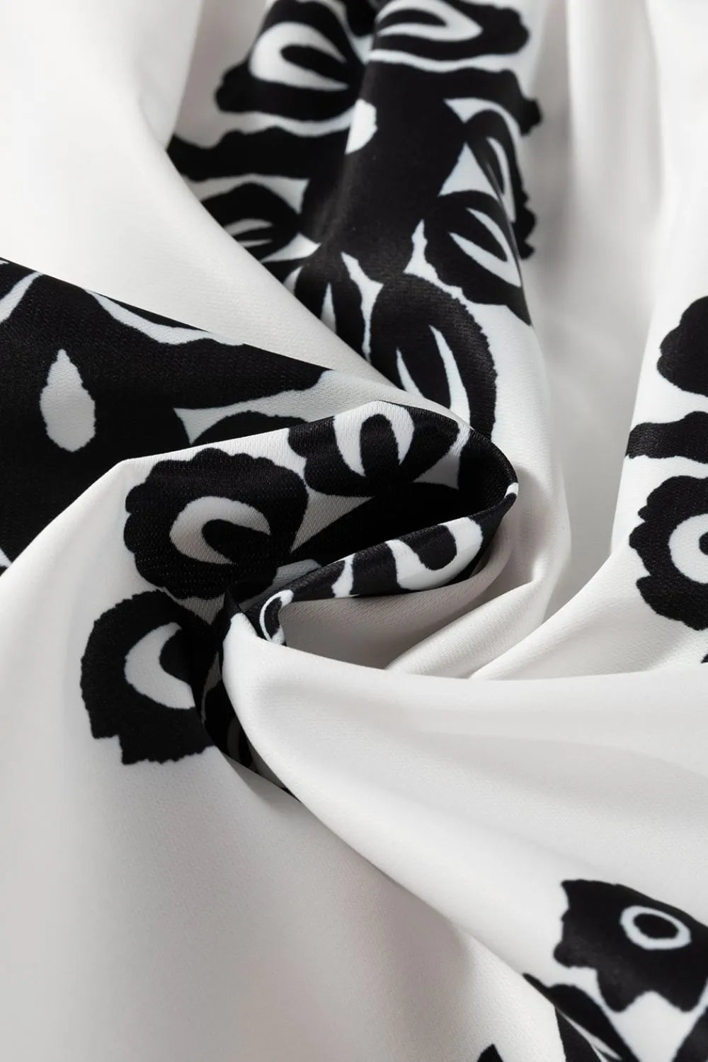 Elegant Tied Printed Shorts featuring a smooth black floral design on white fabric, ideal for chic everyday wear.
