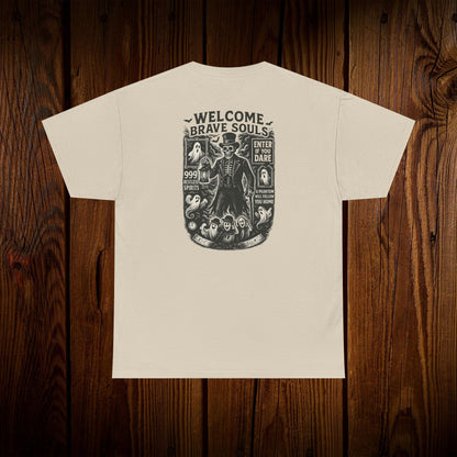 Back view of a Spooky Halloween Graphic Tee with a unique design stating 'Welcome Brave Souls', perfect for Halloween festivities, set on a wooden surface.