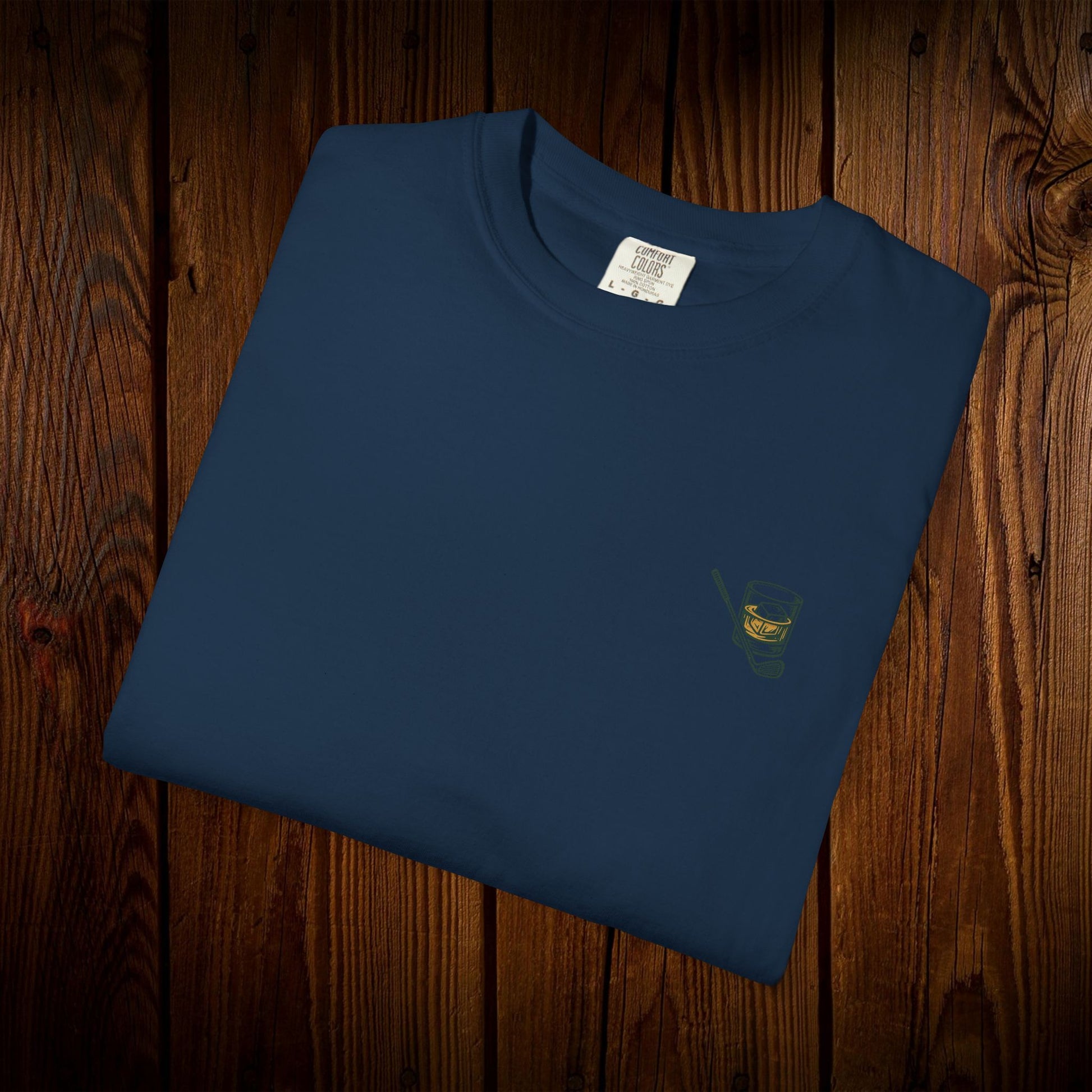 Folded Men's Golf & Whiskey Tee in navy color showing a sleek whisky glass design. Made from soft cotton, this eco-friendly shirt is perfect for golf lovers.