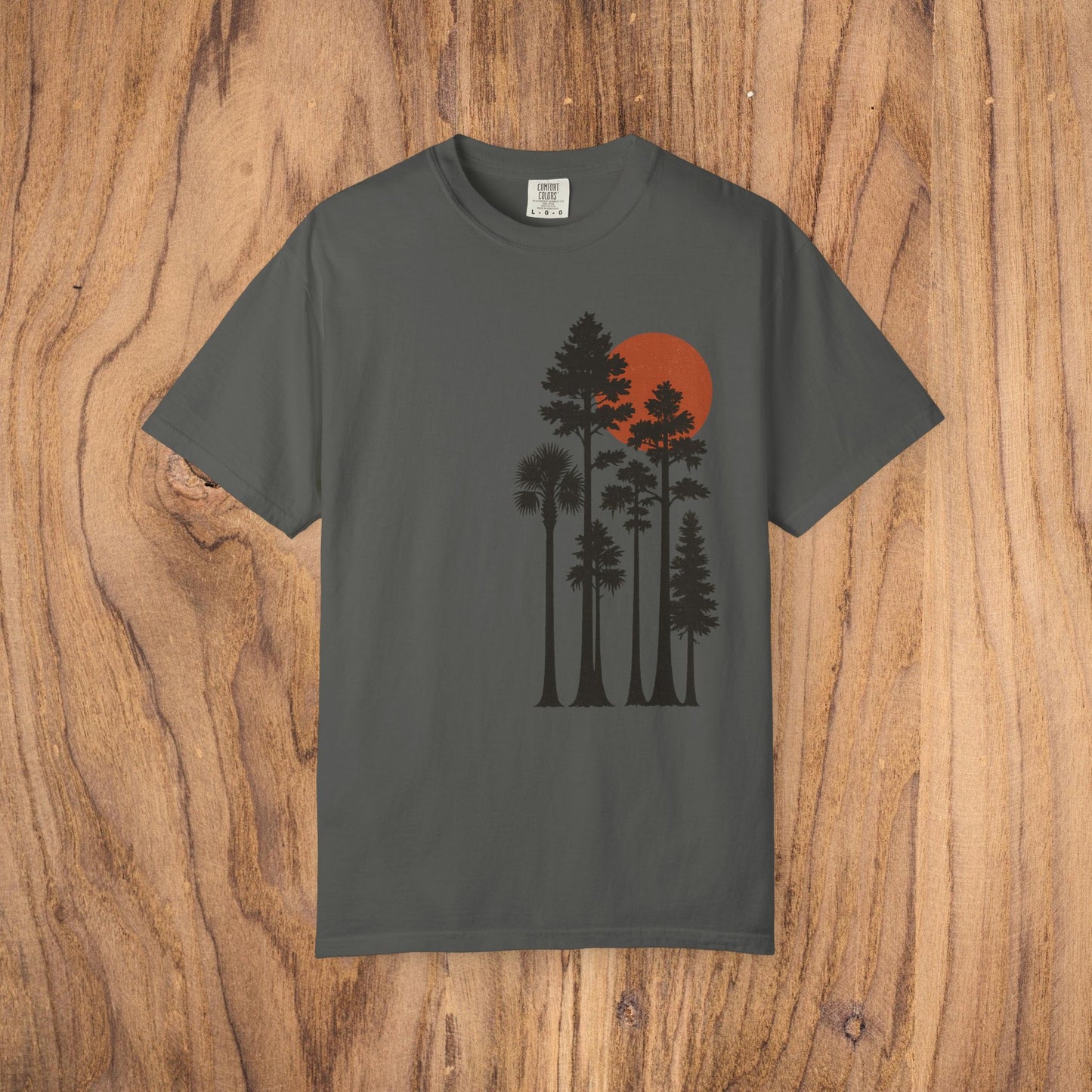 Sunset Trees Unisex T-Shirt in charcoal gray, featuring a beautiful silhouette of trees with a red sunset, made from 100% cotton for a stylish and comfortable everyday look.
