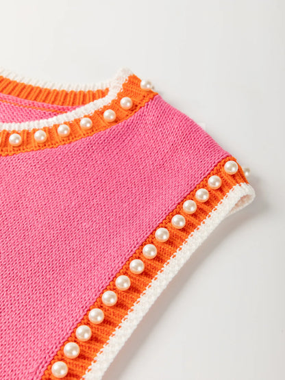 Close-up view of the Stylish Contrast Trim Pearl Detail Sweater Tank Top showcasing its unique pink texture and decorative pearl accents along the armholes.
