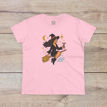 Witchy Night Out Tee in soft pink illustrated with a lively witch on a broomstick, accompanied by celestial designs, made from environmentally friendly, ethically sourced cotton.