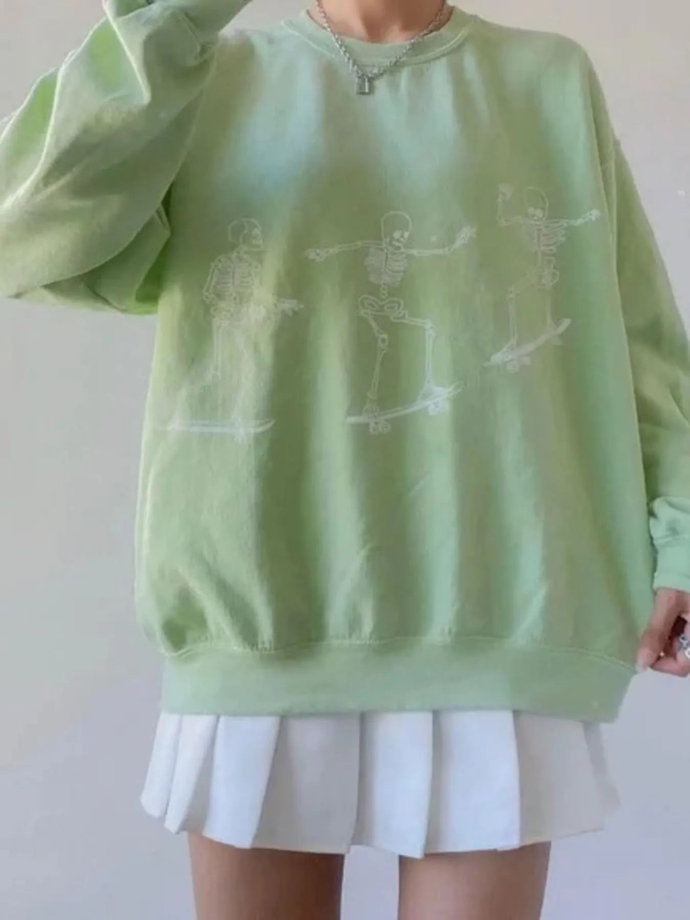 Close-up of the Oversized Skeleton Graphic Sweatshirt for Women in mint green, showing off the fun skeleton graphics and relaxed design.