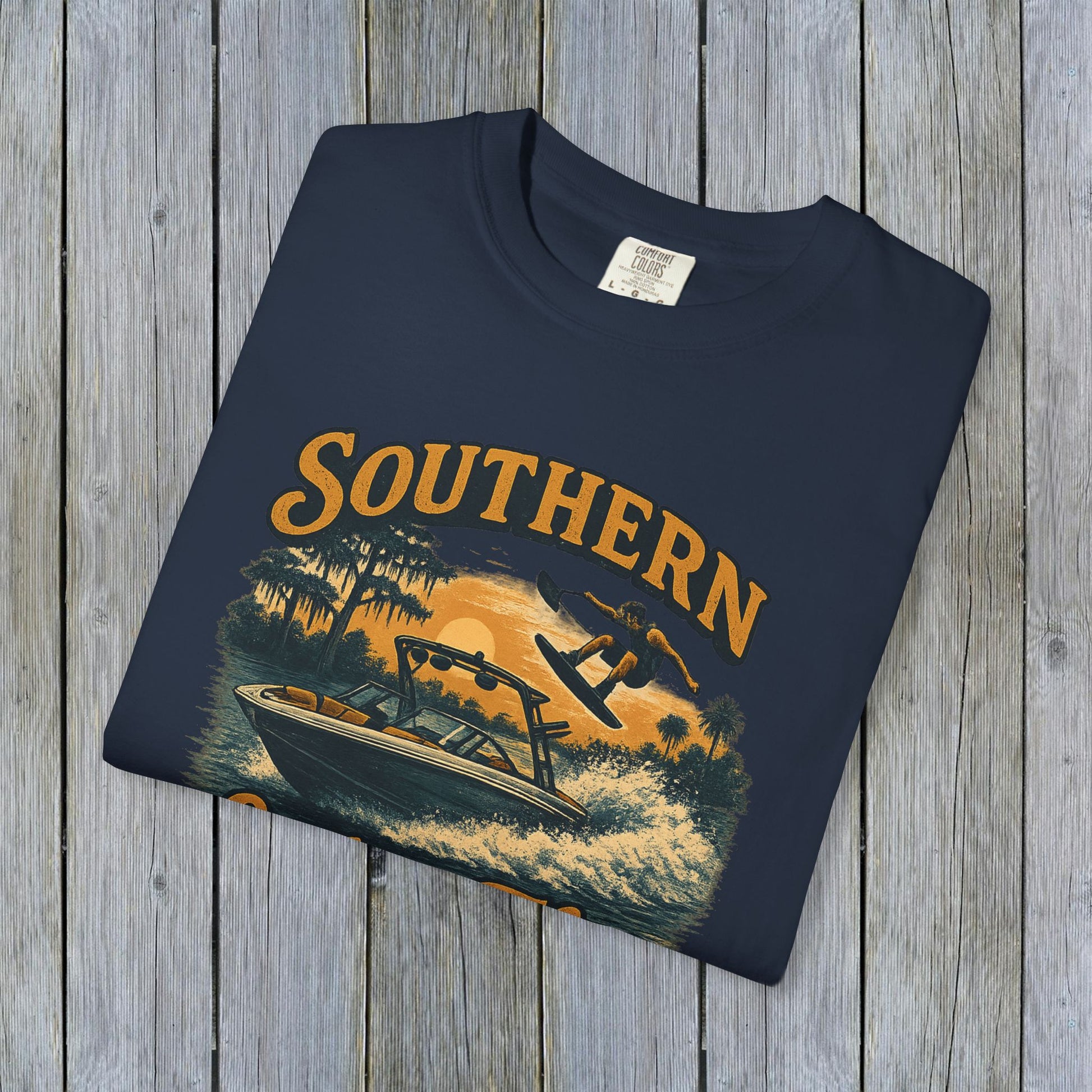 Southern Lake Flow T-Shirt in navy blue color, elegantly displaying an illustration of a wakeboarder on a boat, made from 100% US cotton for sustainability and comfort.