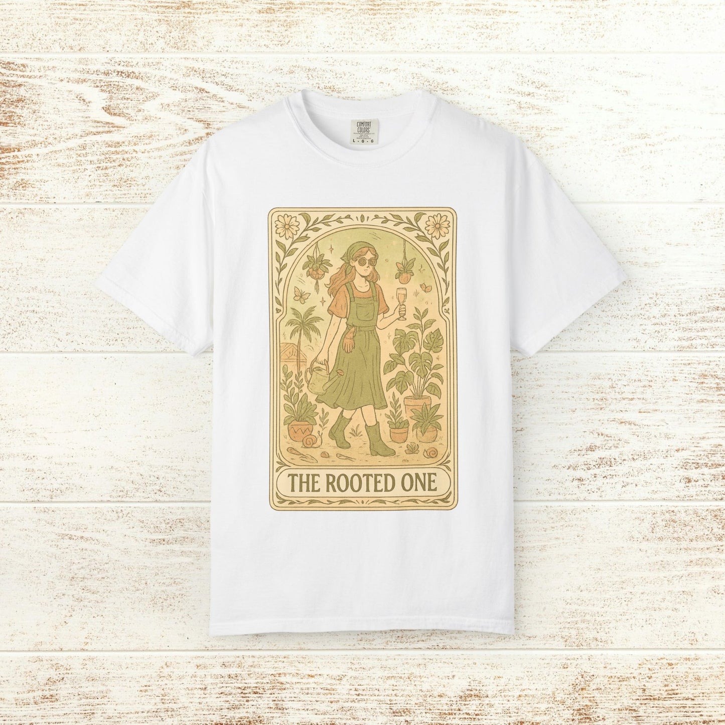 Rooted One Tarot Tee in white, adorned with an artistic depiction of a figure amidst plants. Ideal for those who appreciate unique, ethically made clothing.