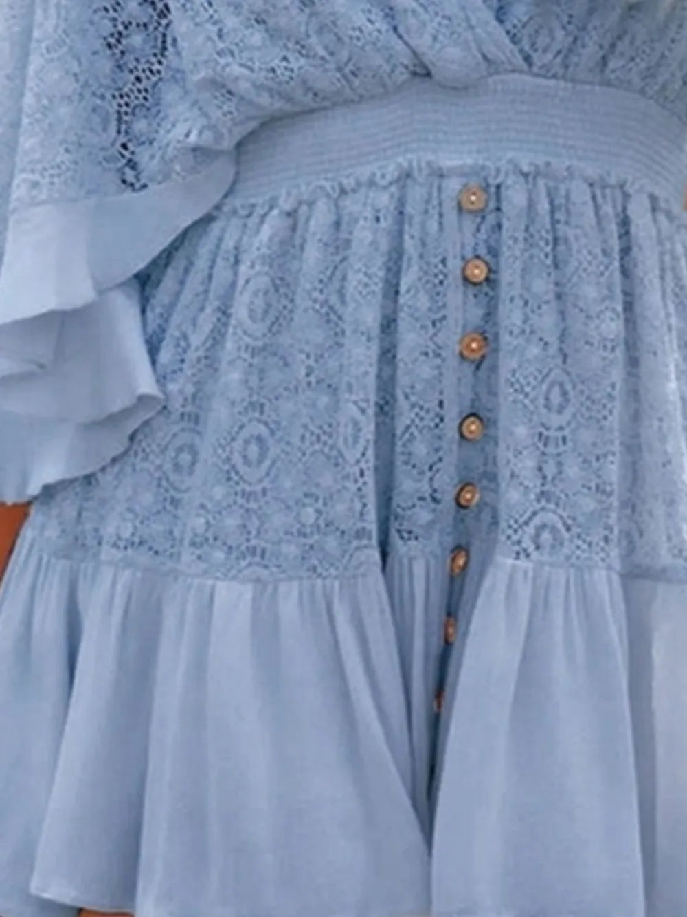 Detailed view of the front of the blue Semi-Sheer Ruffle Hem Lace Mini Dress With Tie Back - Elegant Smocked Design, focusing on button details and lace texture.
