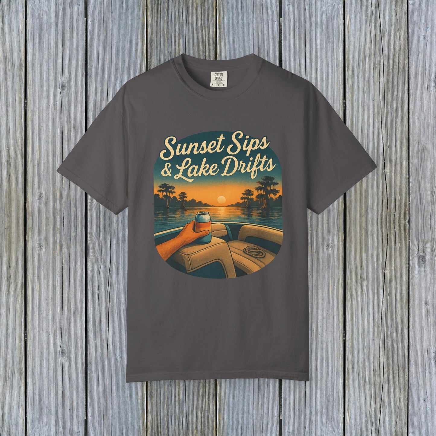 Lake Drifts T-Shirt in charcoal gray featuring a graphic of a hand holding a drink against a sunset background, perfect for casual wear.