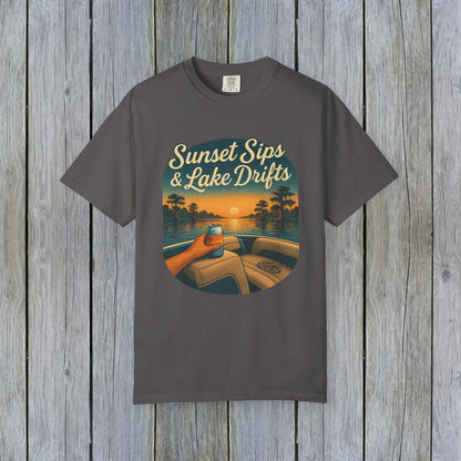 Lake Drifts T-Shirt in charcoal gray featuring a graphic of a hand holding a drink against a sunset background, perfect for casual wear.