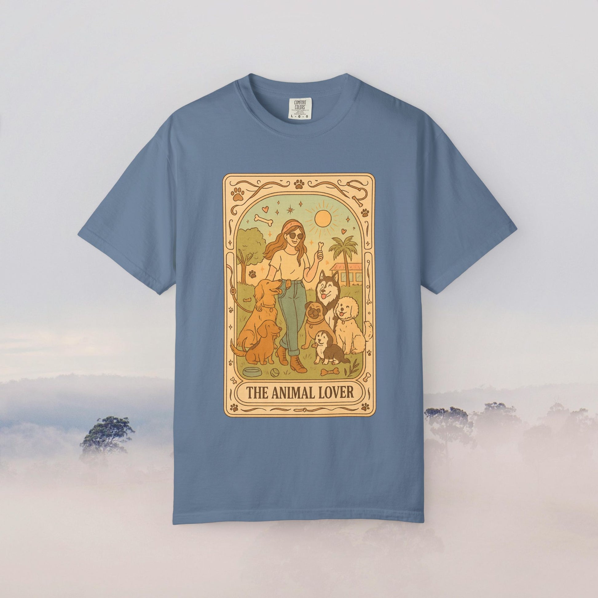 Animal Lover Tarot Tee in a soft blue hue, displaying an artistic representation of a woman surrounded by animals under the sun, ideal for those who cherish pets.