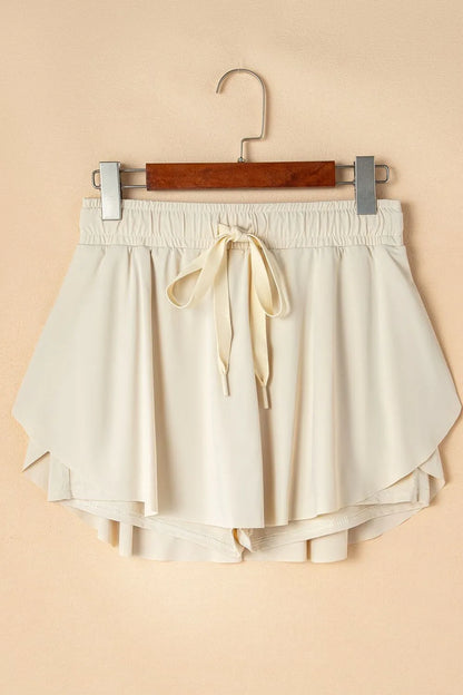 Flat lay of Drawstring High Waist Lined Active Skorts, featuring a drawstring waist and layered shorts for athletic comfort.