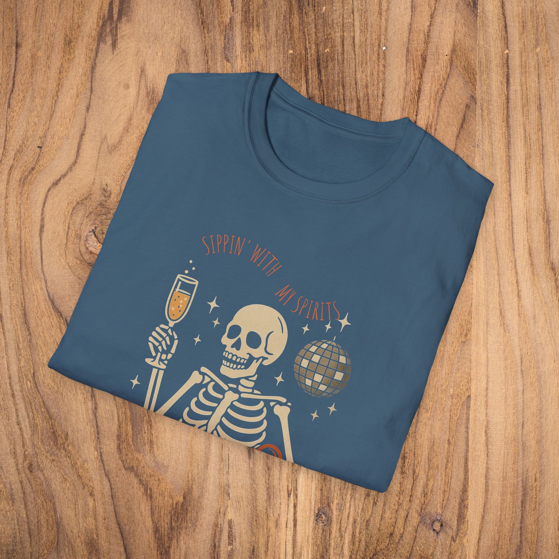 Folded Spooky Spirits Graphic Tee in dark blue color, showcasing a playful skeleton design holding a drink and a disco ball.