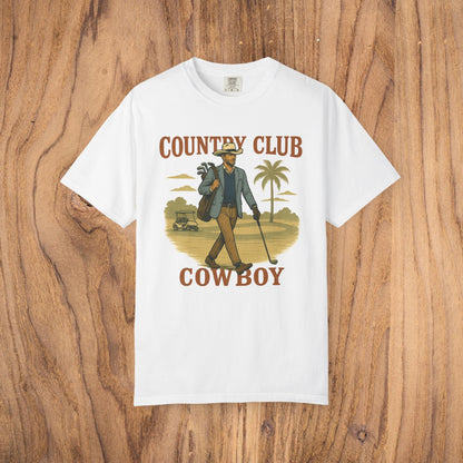 Country Club Cowboy Graphic Tee in white color featuring a cowboy with a golf bag on a backdrop of palm trees, crafted from durable cotton, designed with a ribbed collar and eco-friendly crewneck.