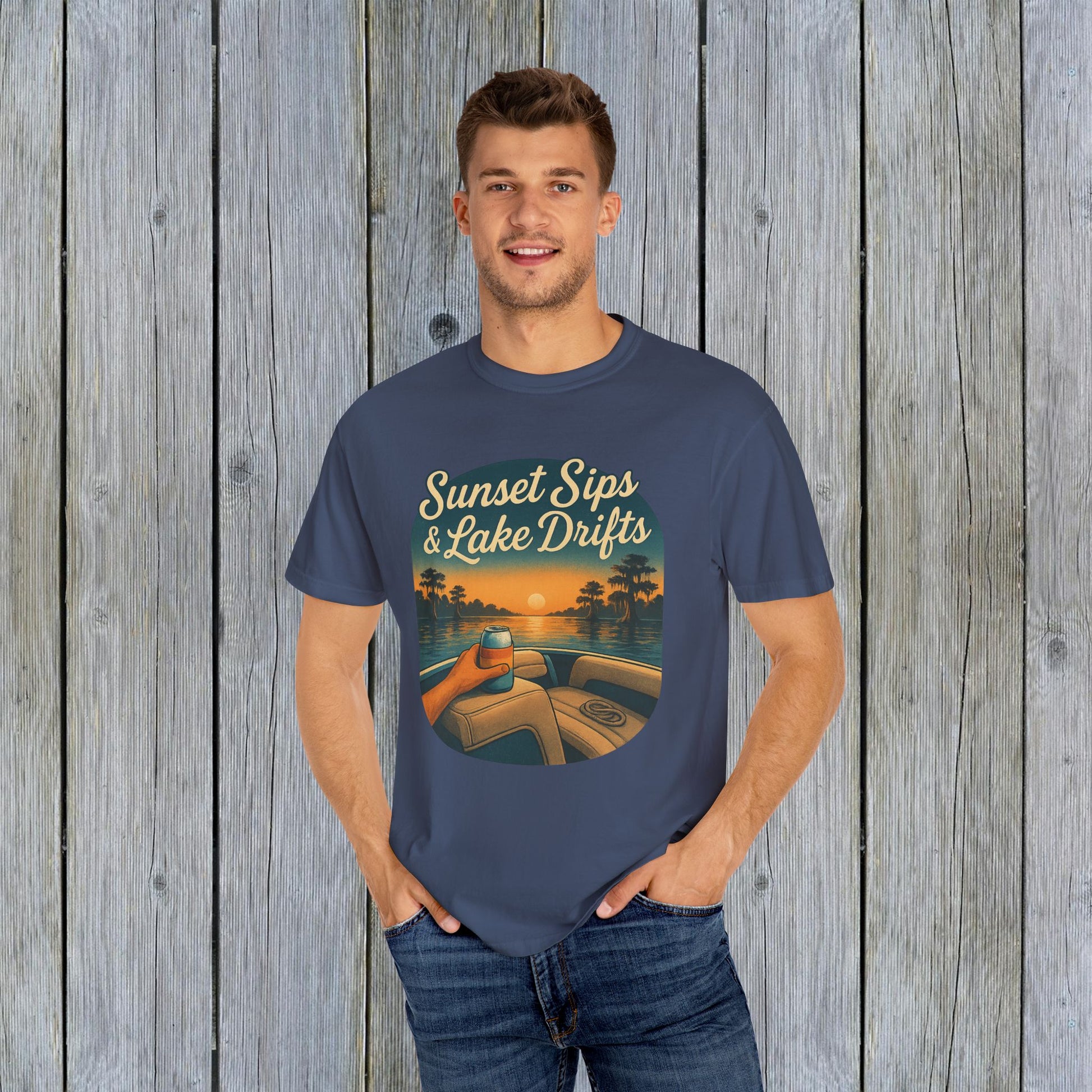 Man dressed in a navy Lake Drifts T-Shirt, featuring a vibrant sunset and lake design, made from soft and durable cotton.