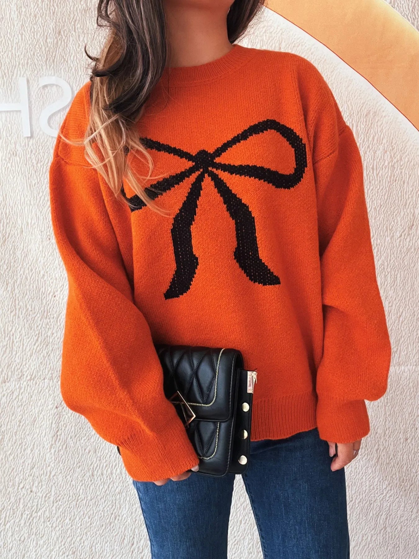 Effortless everyday wear with this stylish bow pattern casual long sleeve sweater in orange. Model pairing with jeans.
