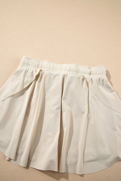 Flat lay of the Drawstring High Waist Lined Active Skorts highlighting the pleated design and breathable fabric texture.