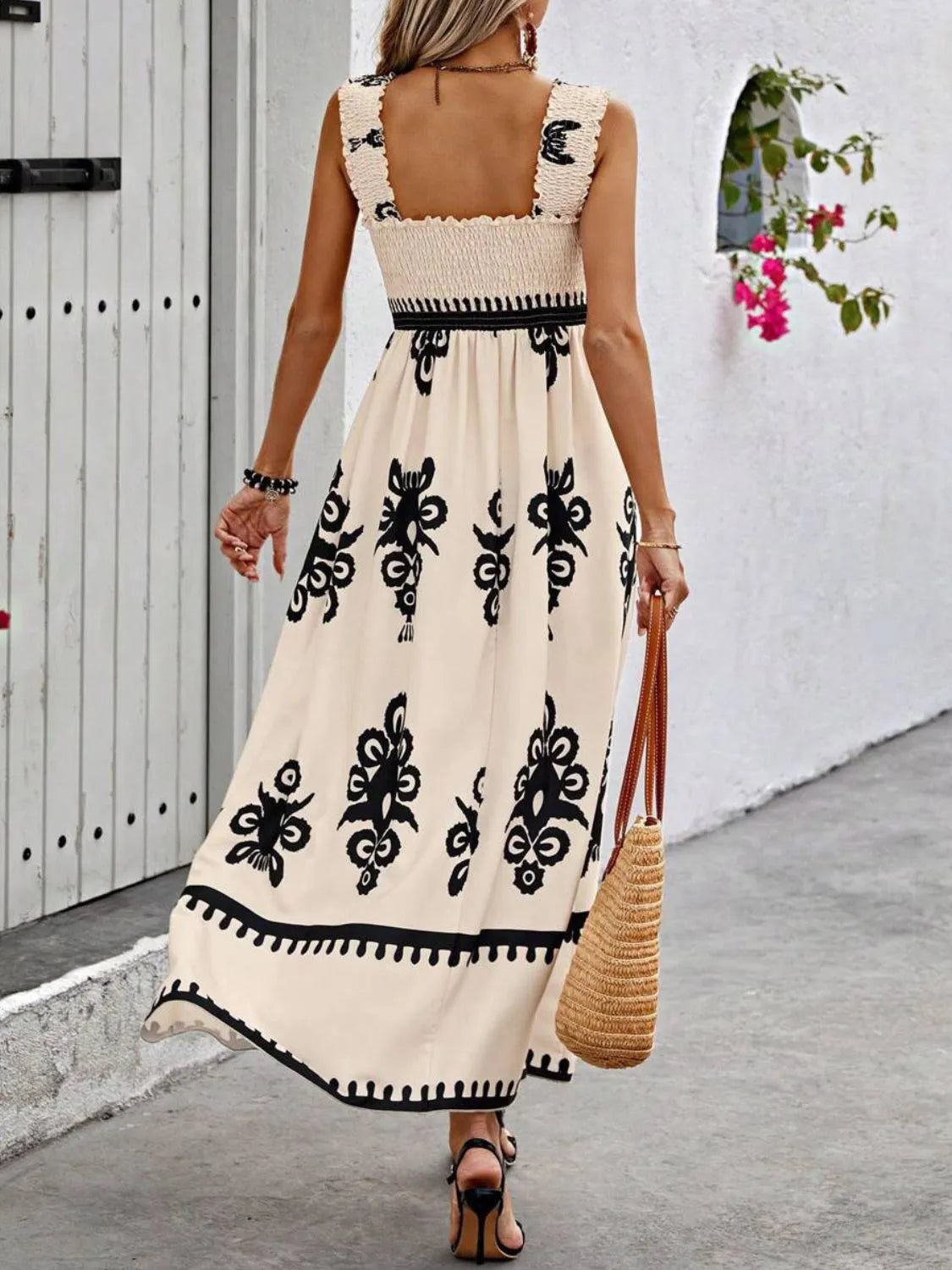 Trendsi Smocked Printed Maxi Dress with Wide Straps - Elegant Opaque, Non-Stretch Design displayed from the back, emphasizing the smocked detail and wide straps, worn by a woman walking on a charming outdoor pathway.