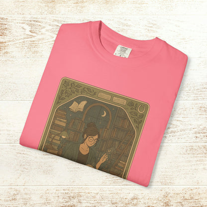 Page Turner Tarot Tee in pink, vibrant soft cotton t-shirt showcasing an enchanting design of a woman amidst books, available in sizes S to 4XL, eco-friendly and comfortable.