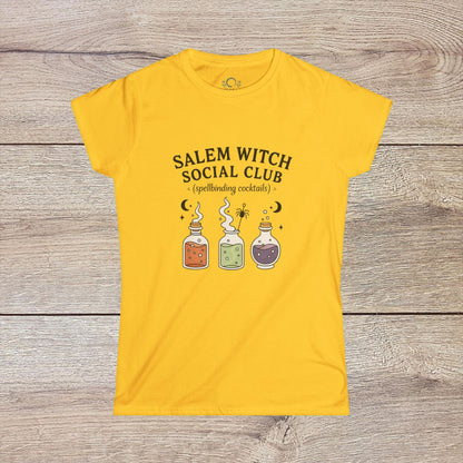 Salem Witch Social Club Graphic Tee displaying enchanting potion bottles and spellbinding cocktails on a bright yellow background, made from soft 100% ring-spun cotton for a whimsical touch.