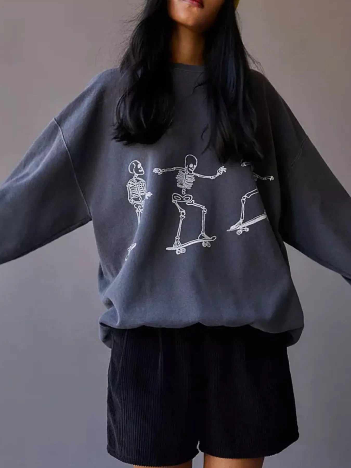 Stylish Oversized Skeleton Graphic Sweatshirt for Women with a playful skeleton skating theme, made of 100% polyester, offering slightly stretchy material.