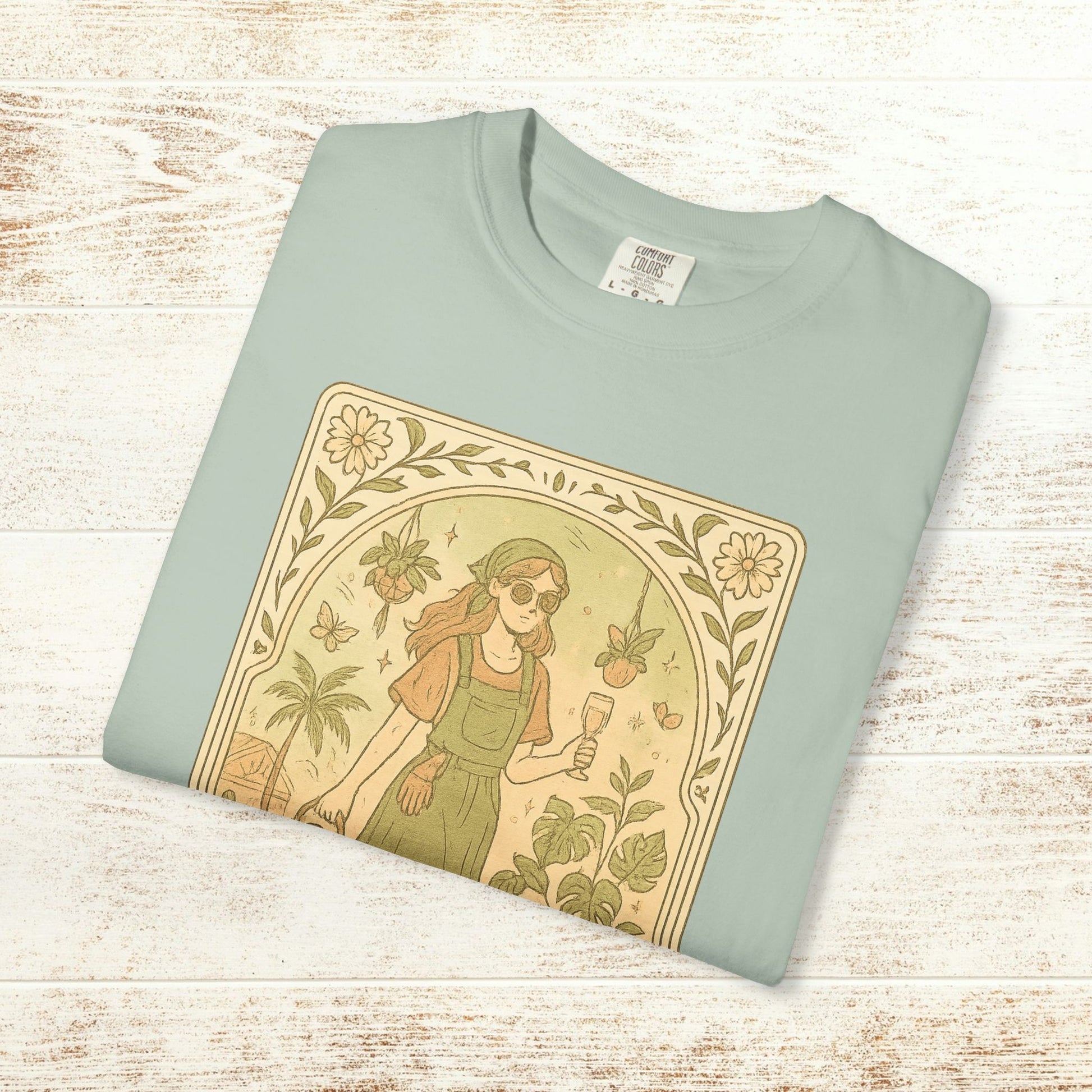 Rooted One Tarot Tee in light mint color featuring a whimsical illustration of a woman surrounded by plants and butterflies - ethically sourced cotton, sizes S-4XL.