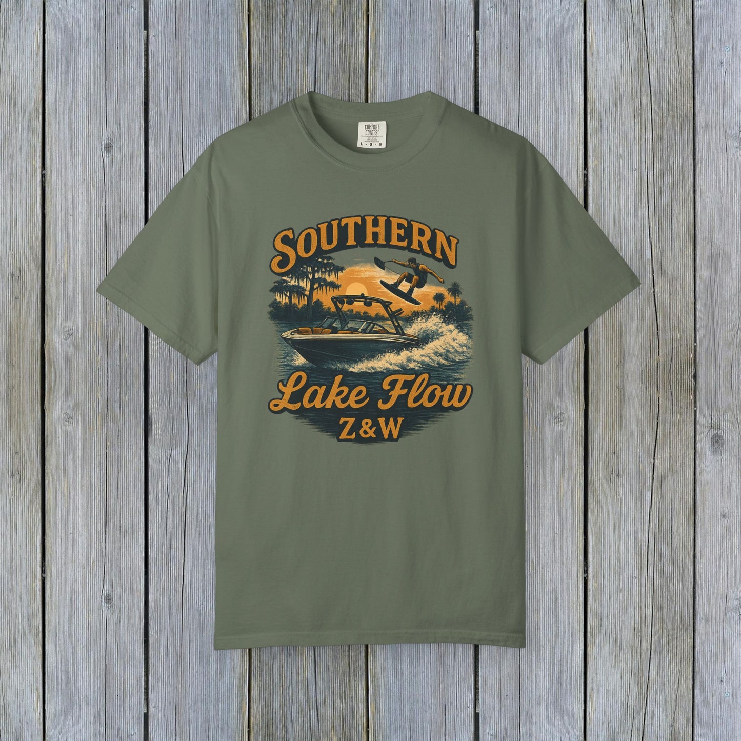 Southern Lake Flow T-Shirt in olive green, featuring an adventurous water skiing illustration, made from 100% US cotton, available in sizes S to 4XL.