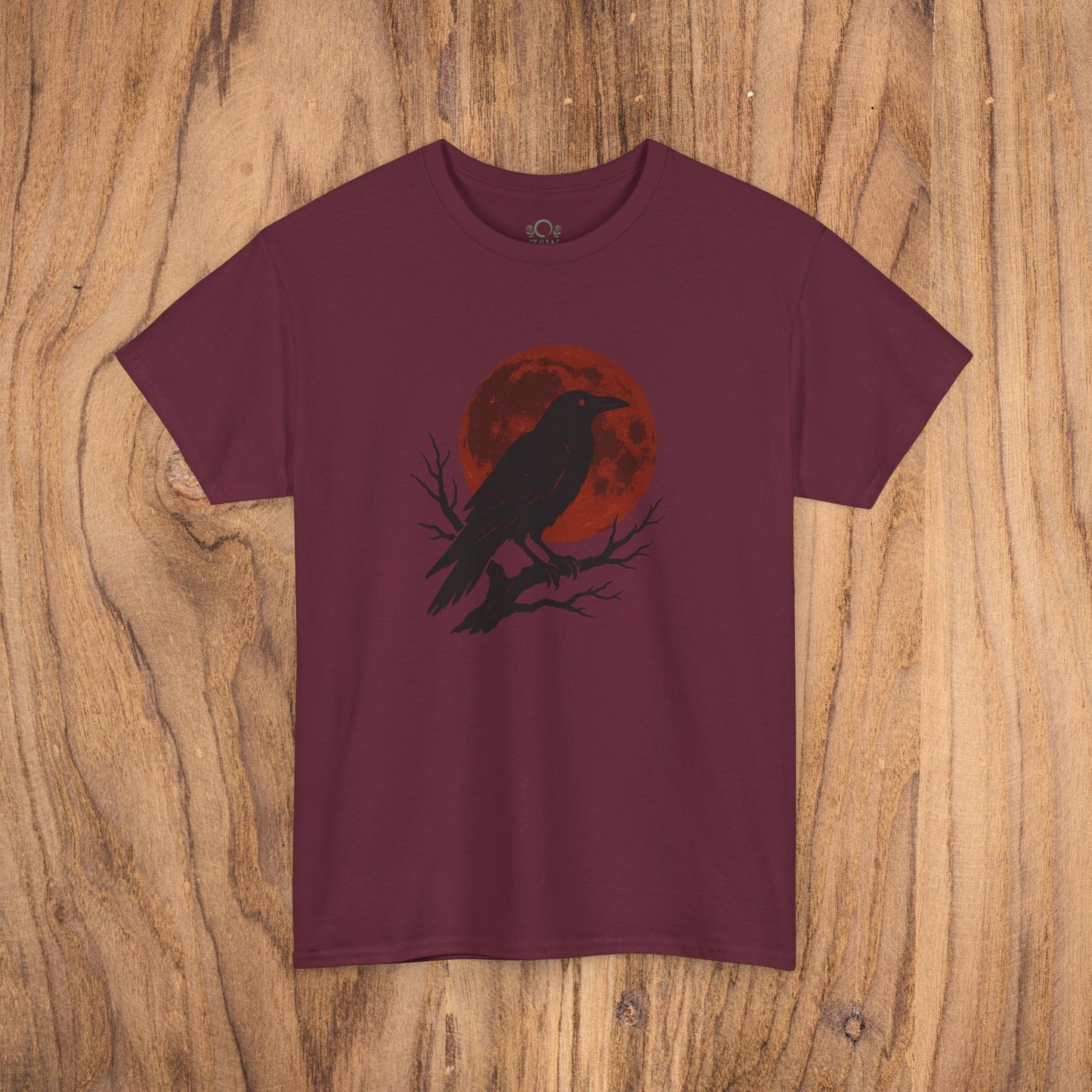 Gothic Raven T-Shirt - Heavy Cotton Tee with a striking design of a black raven and red moon, set against a rustic wooden background, perfect for Halloween parties.