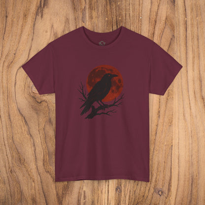 Gothic Raven T-Shirt - Heavy Cotton Tee with a striking design of a black raven and red moon, set against a rustic wooden background, perfect for Halloween parties.