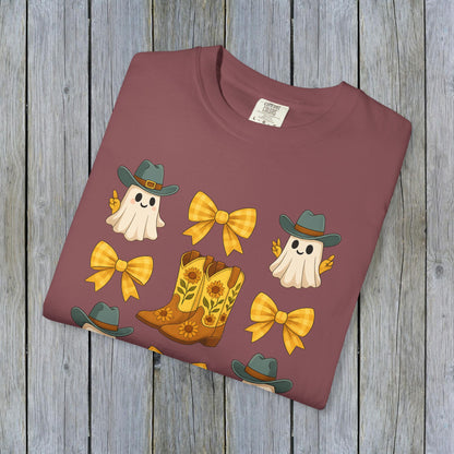 Folded Cute Halloween T-Shirt showcasing ghosts, cowboy boots, and bows in a stylish maroon color. An ideal choice for eco-friendly unisex fall fashion.