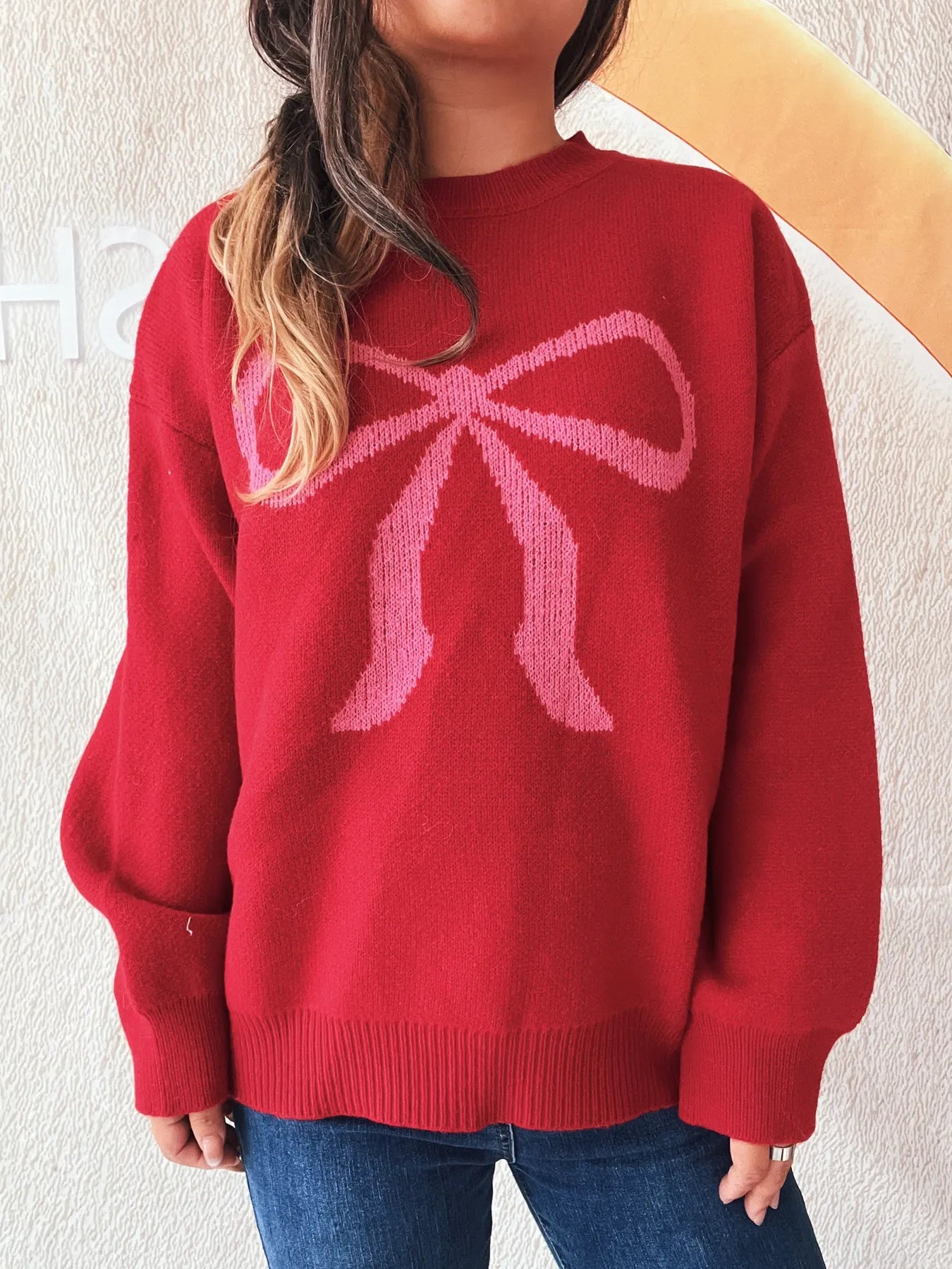 Stylish Bow Pattern Casual Long Sleeve Sweater for Effortless Everyday Wear displayed on a model wearing blue jeans, showcasing the red color and bow design.