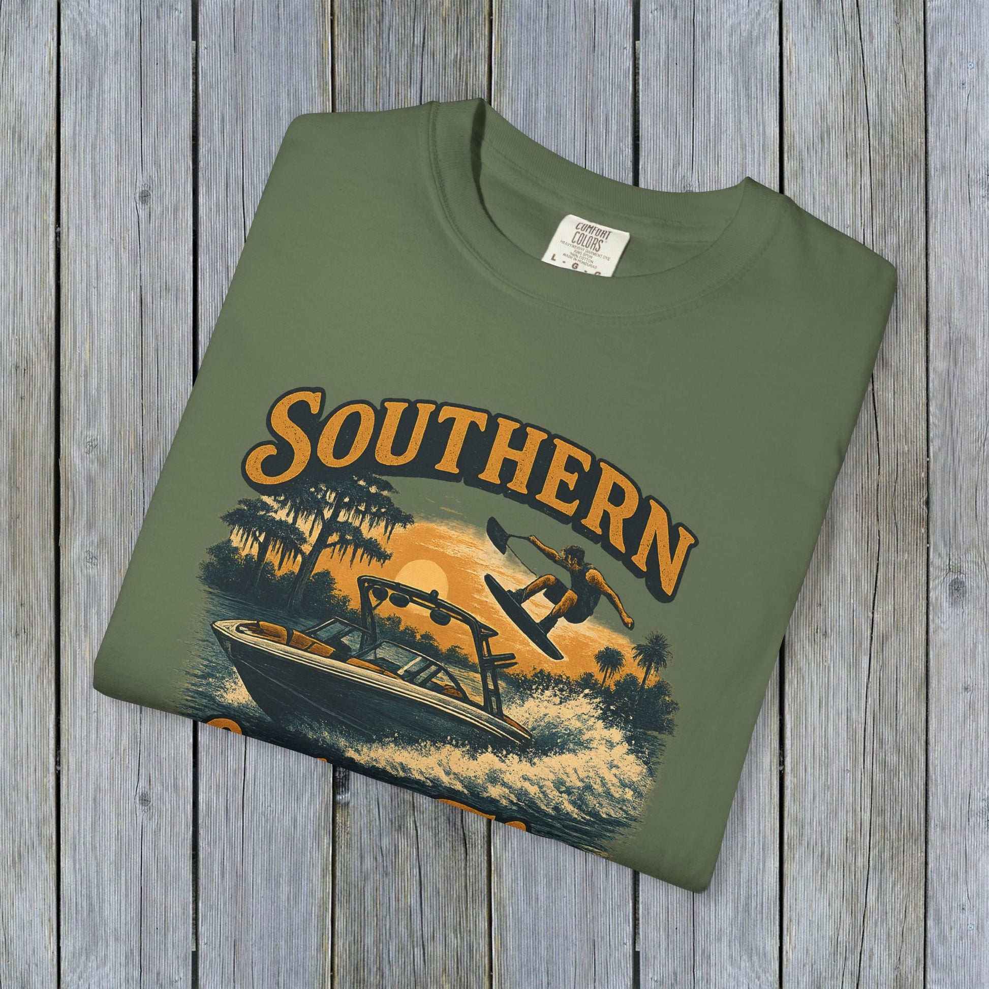 Folded Southern Lake Flow T-Shirt in green, featuring a dynamic water sports graphic, made from durable eco-friendly materials.
