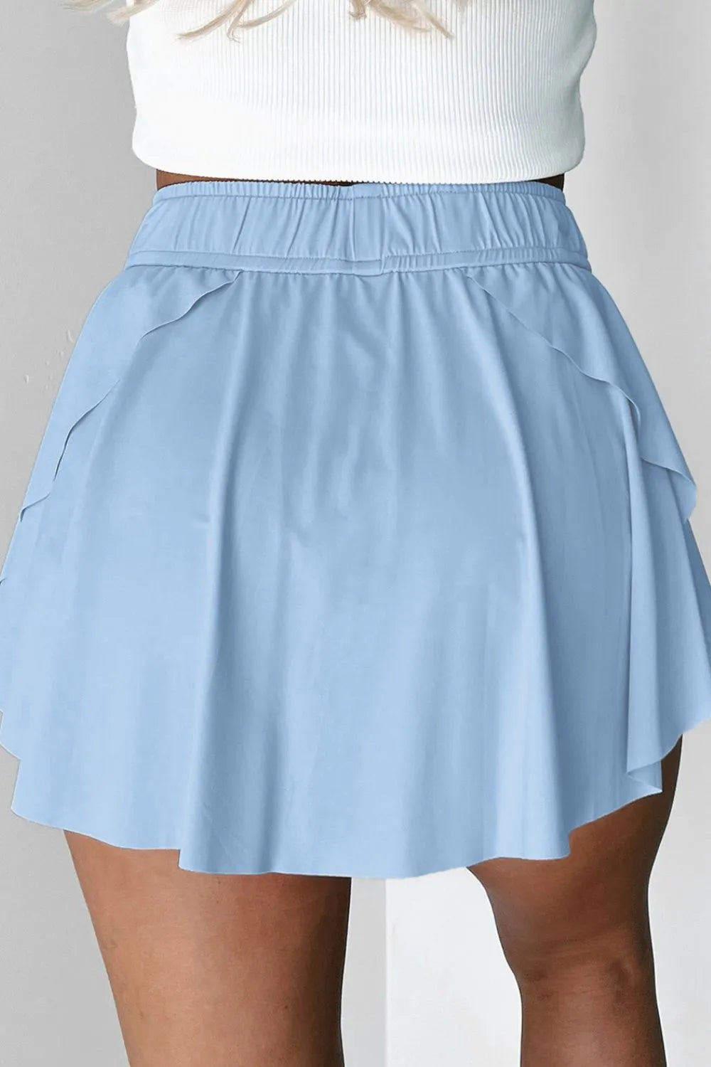 Rear angle of the Drawstring High Waist Lined Active Skorts in light blue, featuring an adjustable waistband and flattering shape for athletic activities.