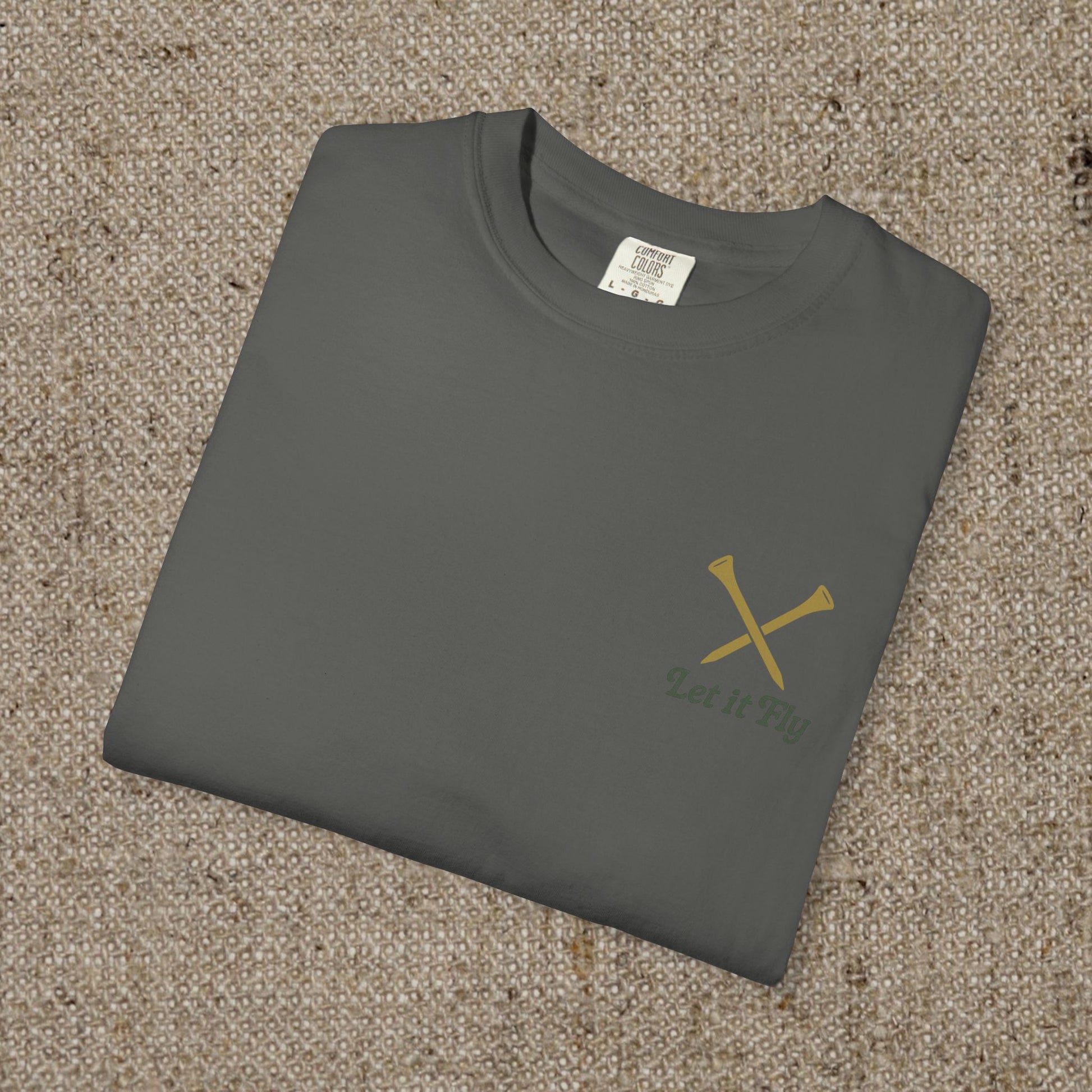 Tee It High Let It Fly Graphic Tee folded neatly, in a dark gray color with crossed golf clubs design, made from soft US cotton for a versatile and stylish wear.