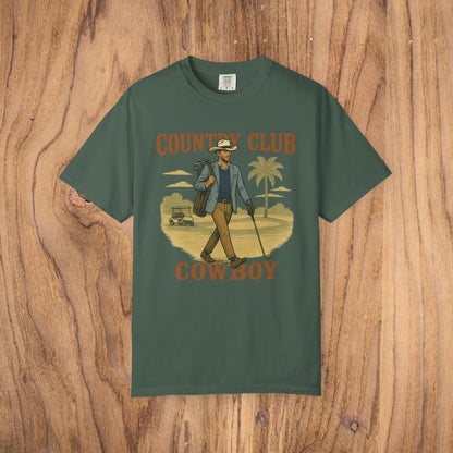 Country Club Cowboy Graphic Tee in dark green, showcasing a stylish cowboy with golf clubs and palm trees. Crafted from eco-friendly cotton fabric, perfect for golf enthusiasts.