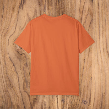Back view of the orange Country Club Cowboy Graphic Tee on a wooden surface, showcasing the shirt's minimalist style.
