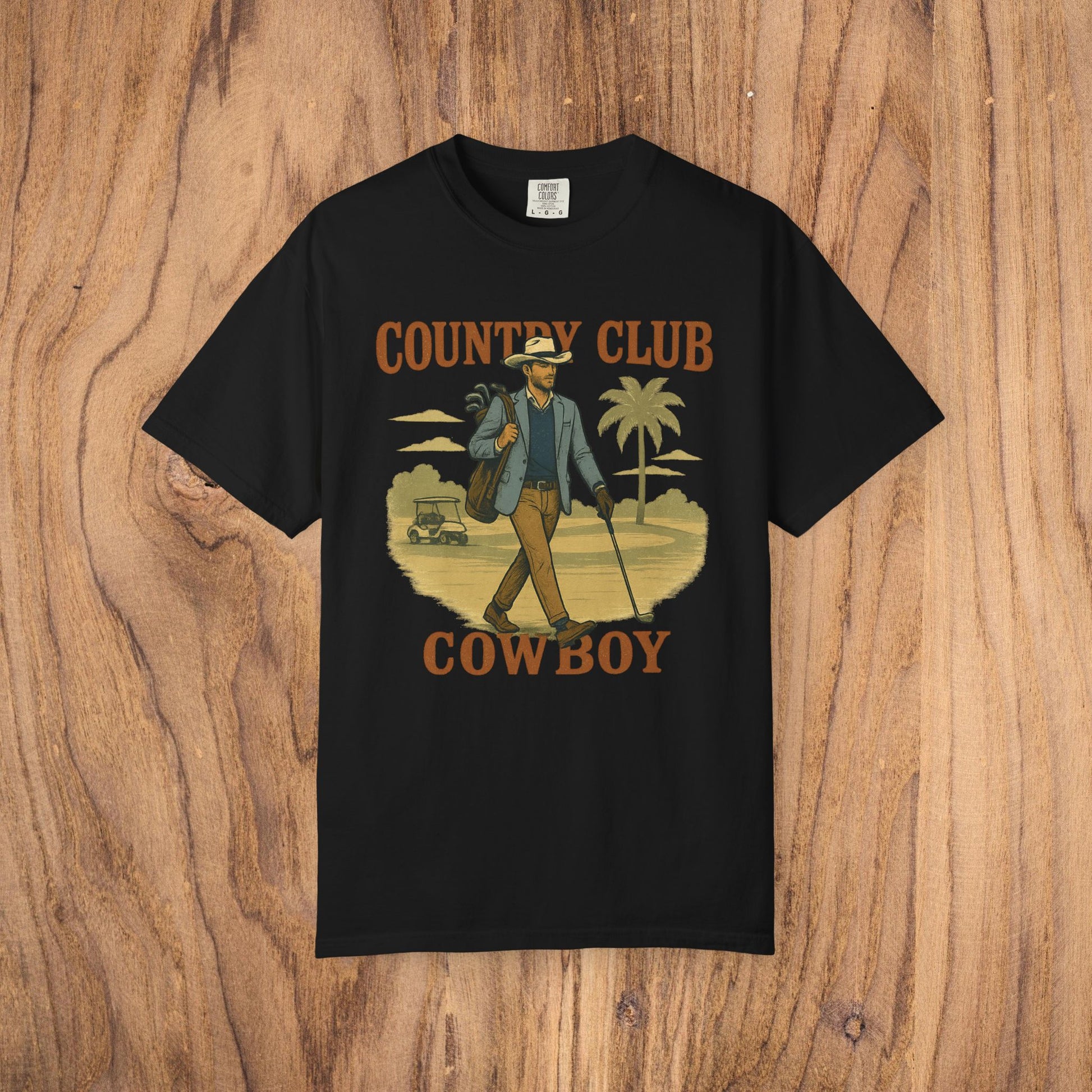 Country Club Cowboy Graphic Tee in black adorned with a cowboy walking with a golf bag in a palm tree setting, made from top-quality cotton, featuring a ribbed collar and an eco-friendly crewneck design.