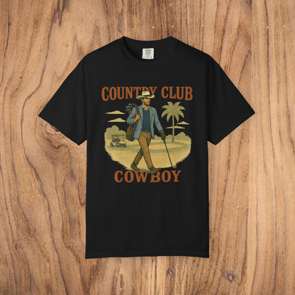 Country Club Cowboy Graphic Tee in black adorned with a cowboy walking with a golf bag in a palm tree setting, made from top-quality cotton, featuring a ribbed collar and an eco-friendly crewneck design.