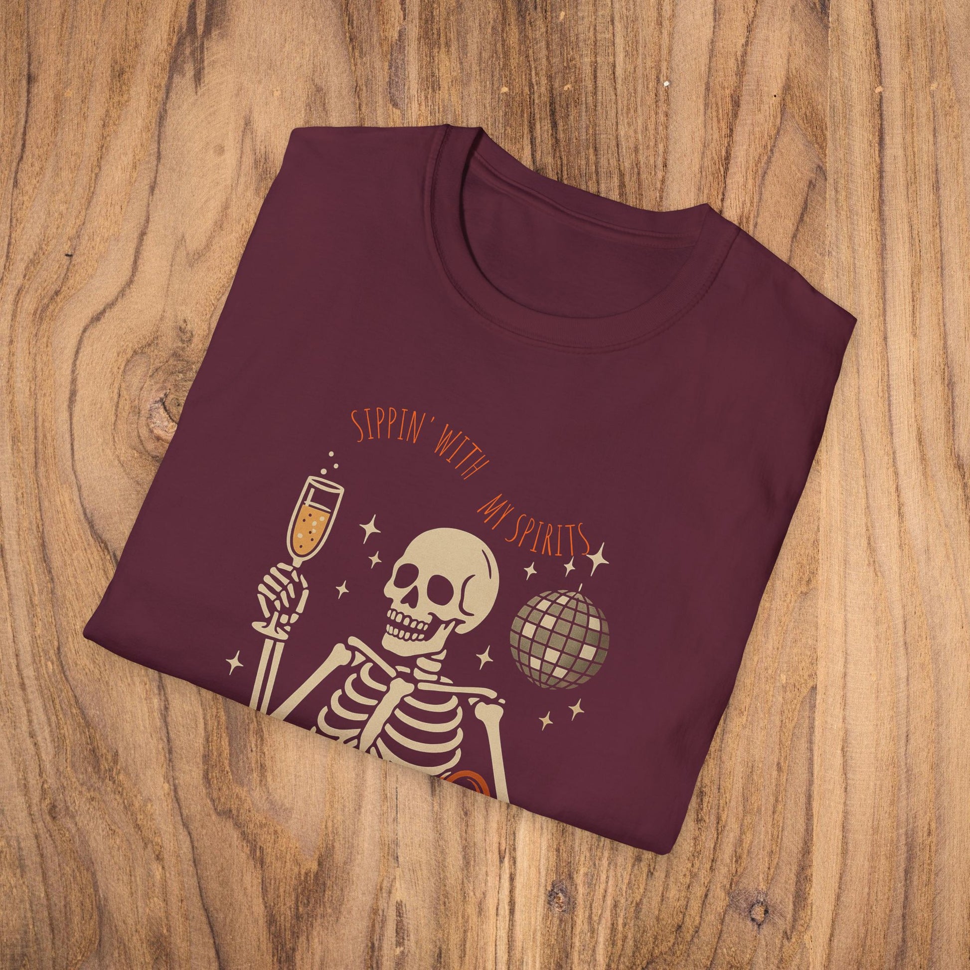Spooky Spirits Graphic Tee in burgundy showcasing a skeleton with a drink, ideal for a fun Halloween look.