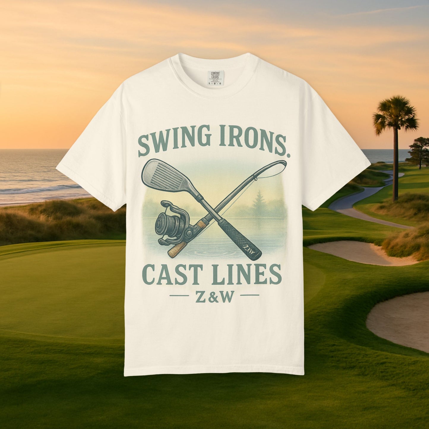 Swing Irons Cast Lines T-Shirt showcased against a scenic golf course backdrop, highlighting its unique graphic with golf clubs and fishing imagery, crafted from soft 100% cotton.