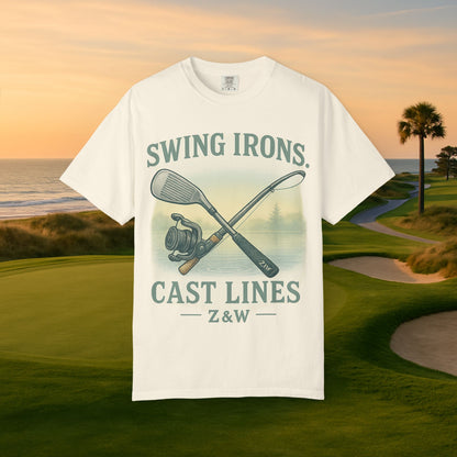 Swing Irons Cast Lines T-Shirt showcased against a scenic golf course backdrop, highlighting its unique graphic with golf clubs and fishing imagery, crafted from soft 100% cotton.