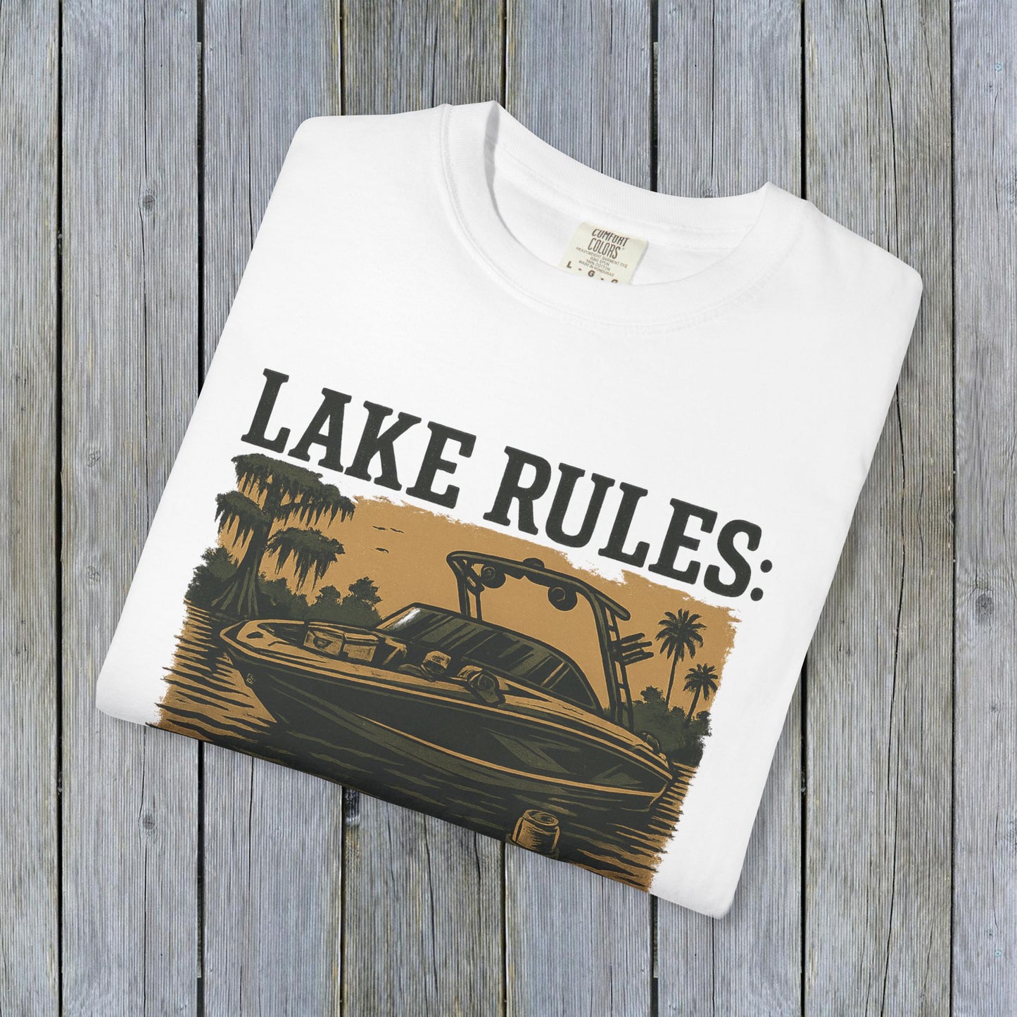 Close-up of the folded Unisex Garment-Dyed Lake Rules Tee featuring a vintage-style print of a boat, emphasizing the unique garment-dyed fabric.